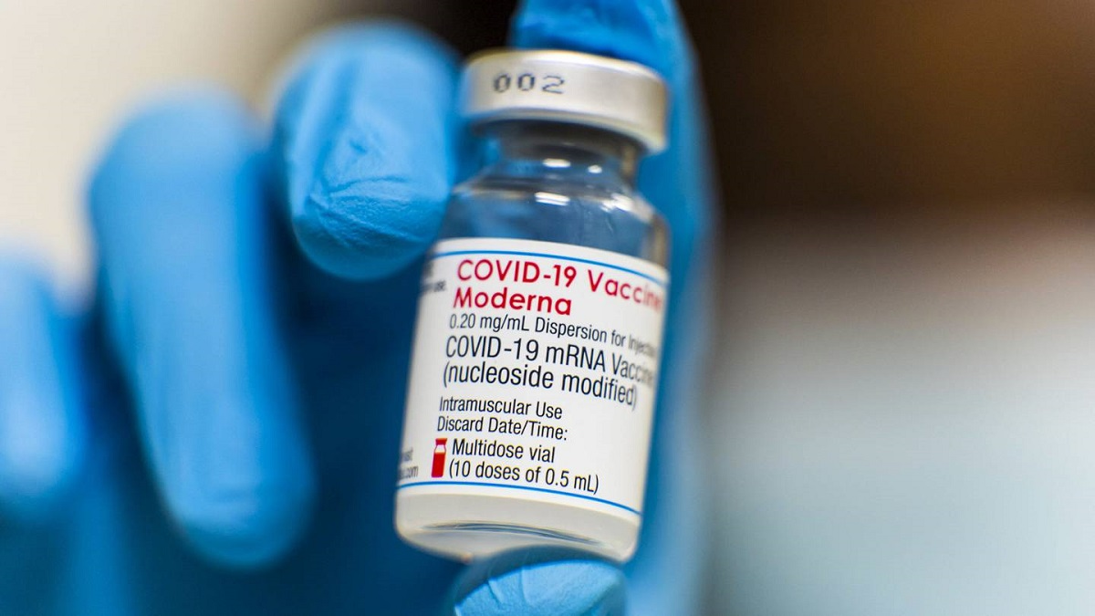 Un empleado de Salud sostiene una vacuna de Moderna.