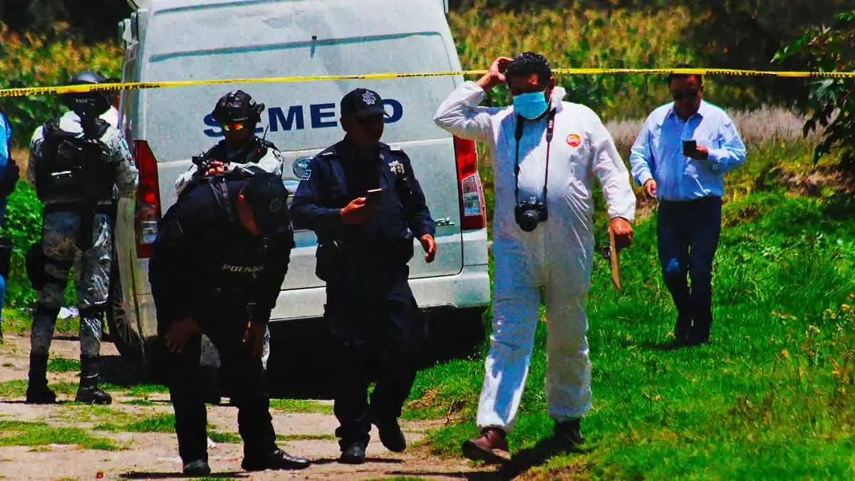Elementos de seguridad pública y peritos frente a zona acordonada.